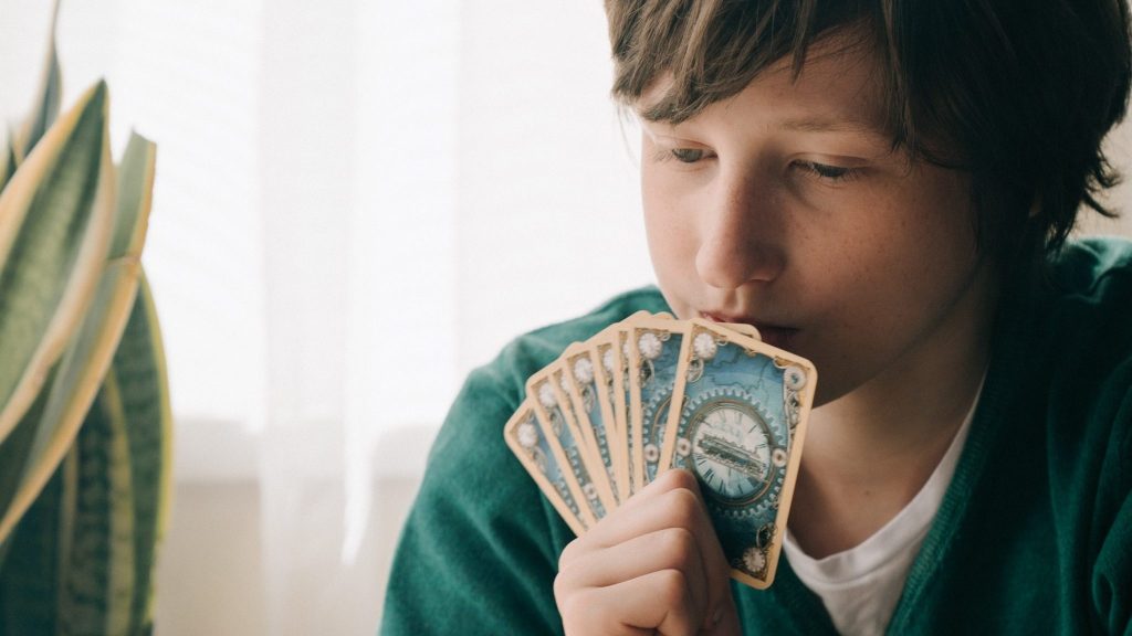 person in green shirt holding playing cards to represent hearing loss strategy