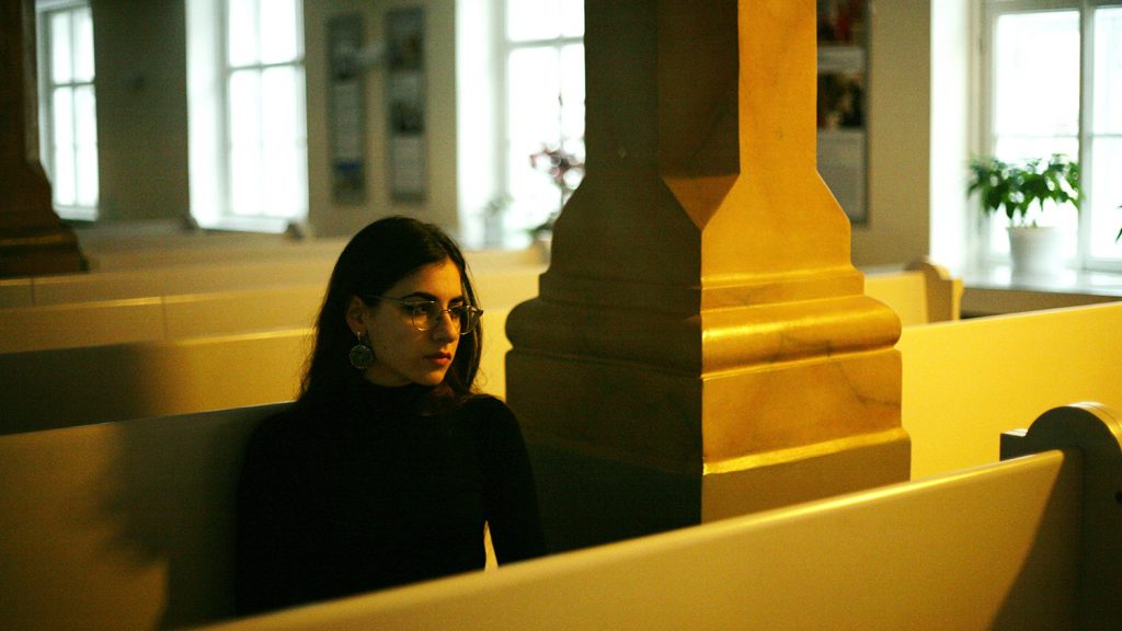 Woman in church alone as an example of the need for hearing accessibility in places of worship