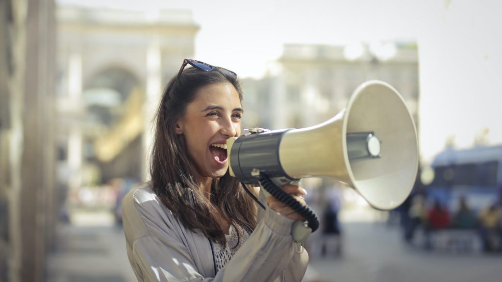 woman yelling into megaphone as an example of amplifiers for hearing loss