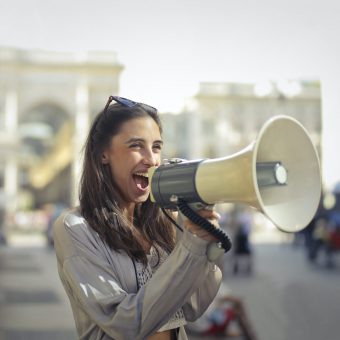woman yelling into megaphone as an example of amplifiers for hearing loss